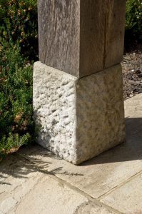 Textured cast stone staddle stone on wooden post