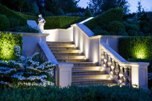 A beautifully landscaped garden staircase finished with Chilstone's handcrafted cast stone steps and balustrade, neatly finished with coping stones and decorated with a classical statue as a show piece.