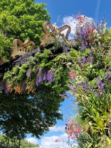 Queens gate at chelsea flower show 2022 is huge living floral arch with foliage and wildflowers and wicker crowns decorating the top as part of the jubilee celebrations in the gardens