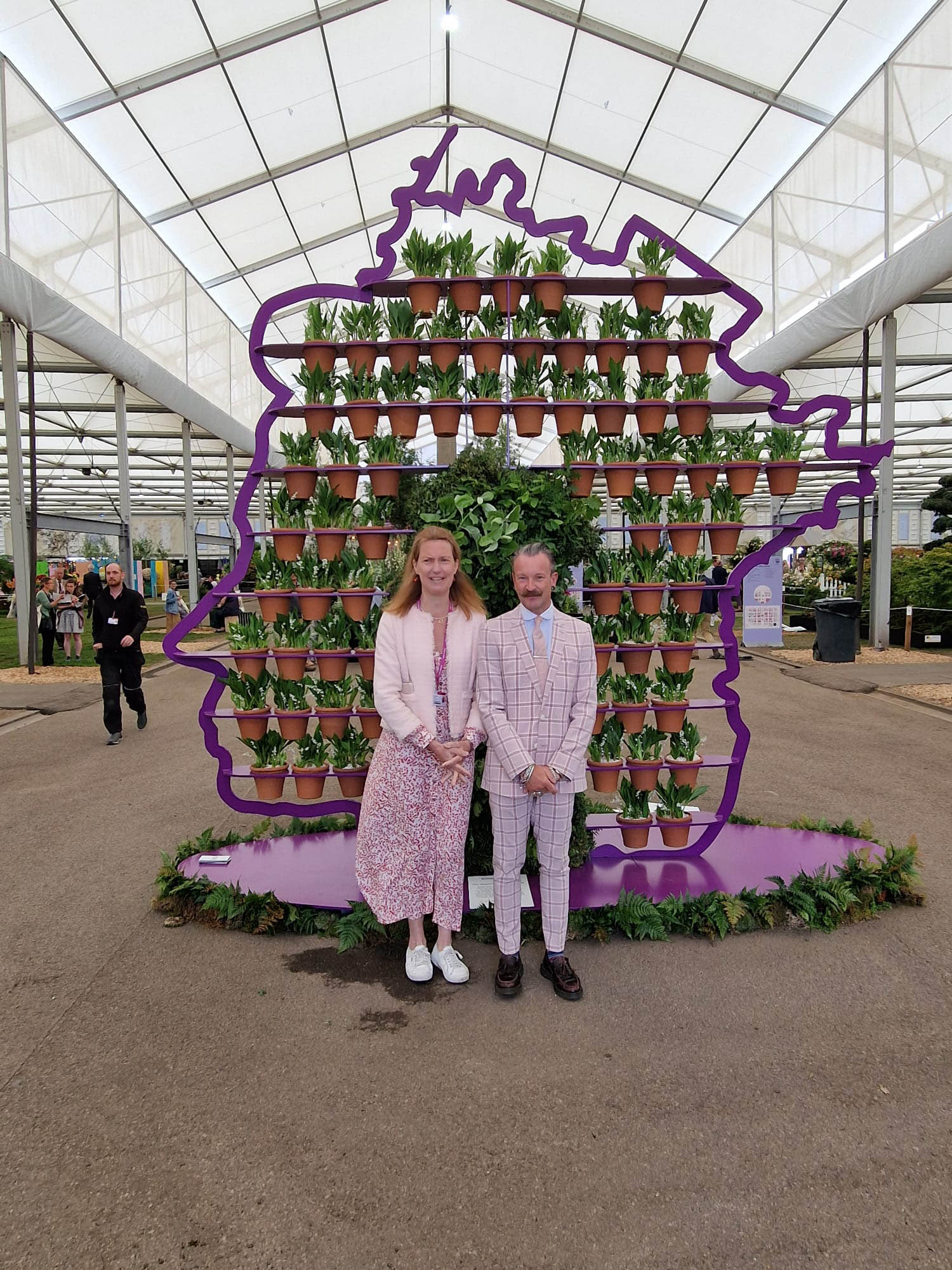 Simon Lycett garden designer standing in front of his amazing 3D silhouette portrait of the Queen made from foliage and 70 pots of HRM favourite flower Lilly of the valley representing 70 years on the thrown as part of the jubilee celebrations in the gardens