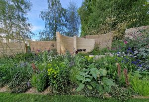 Curved stone walls and wildflowers create a calm and serene atmosphere in the Mind charity garden for mental health at Chelsea 2022