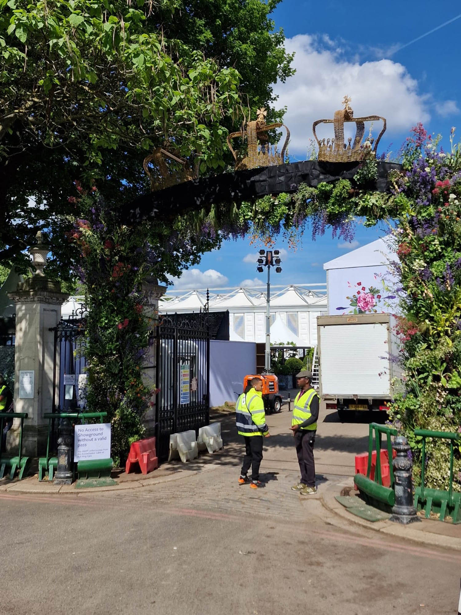 Queens gate at chelsea flower show 2022 is huge living floral arch with foliage and flowers and wicker crowns decorating the top as part of the jubilee celebrations in the gardens