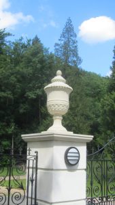 A large Chilstone lidded urn as a final on top of gate pier capitals.